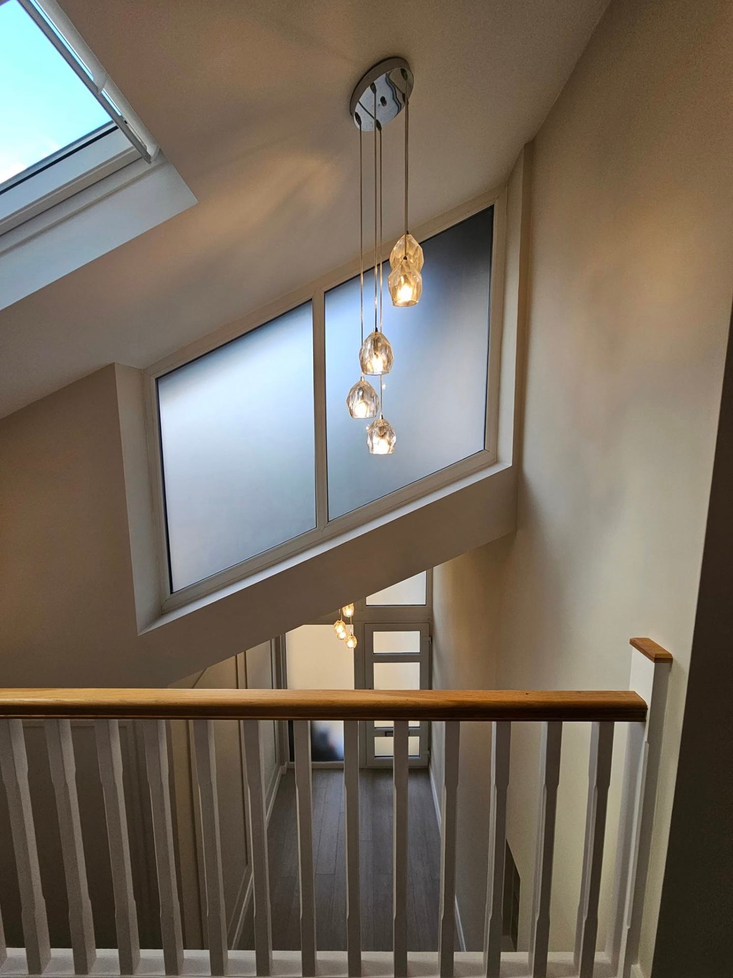 Modern landing with painted spindles and warm neutral walls in a Newport home