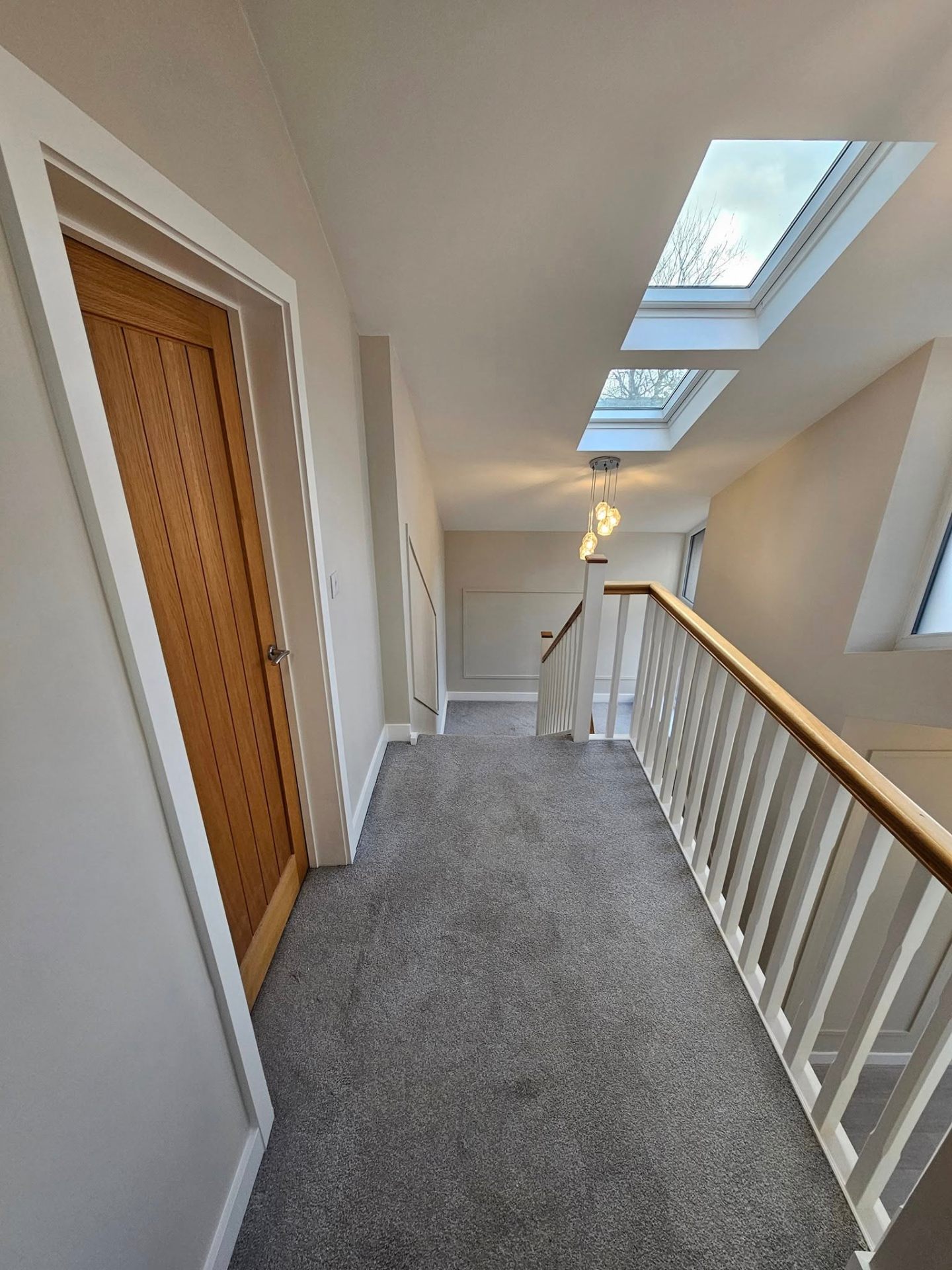 Upstairs hallway in soft greige with new oak doors — South Wales interior decorating