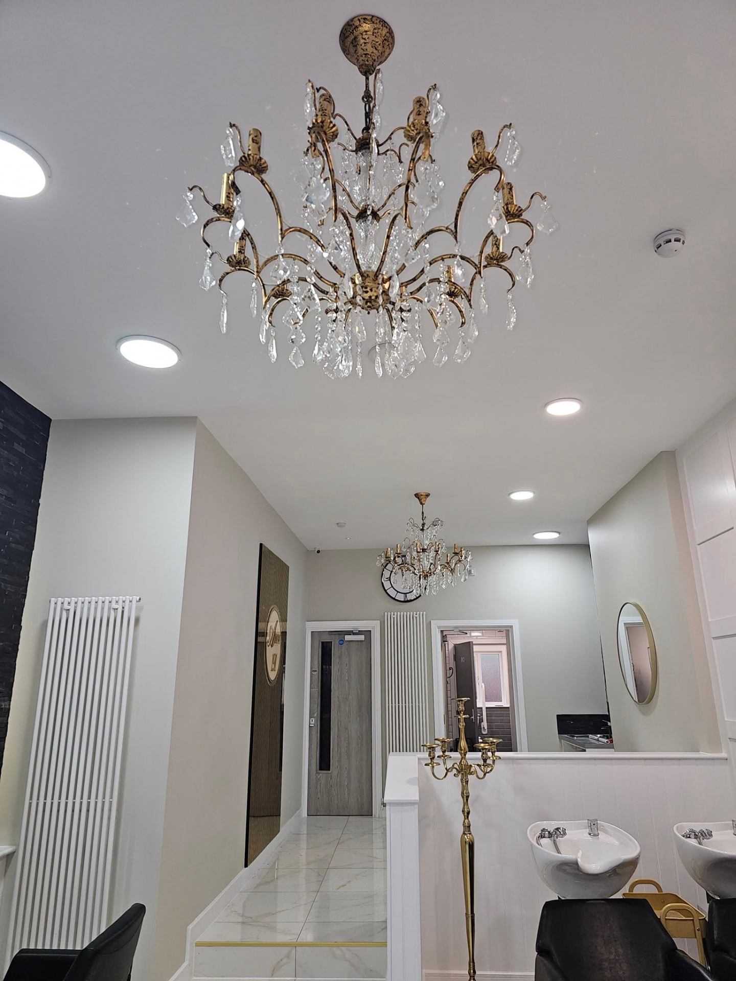 Painted hair salon interior with statement chandelier and bright neutral walls