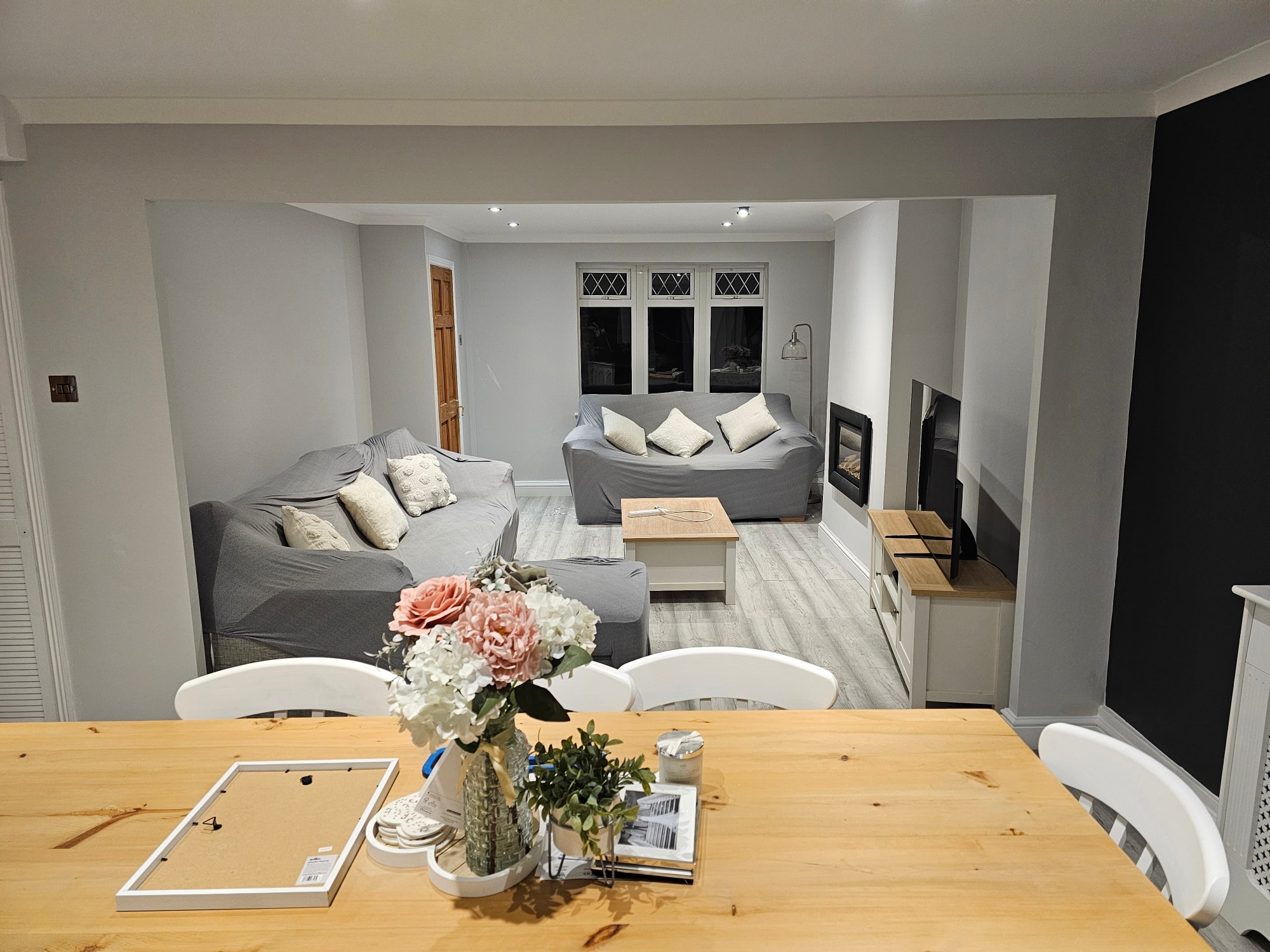 Open-plan living with charcoal feature wall and grey palette