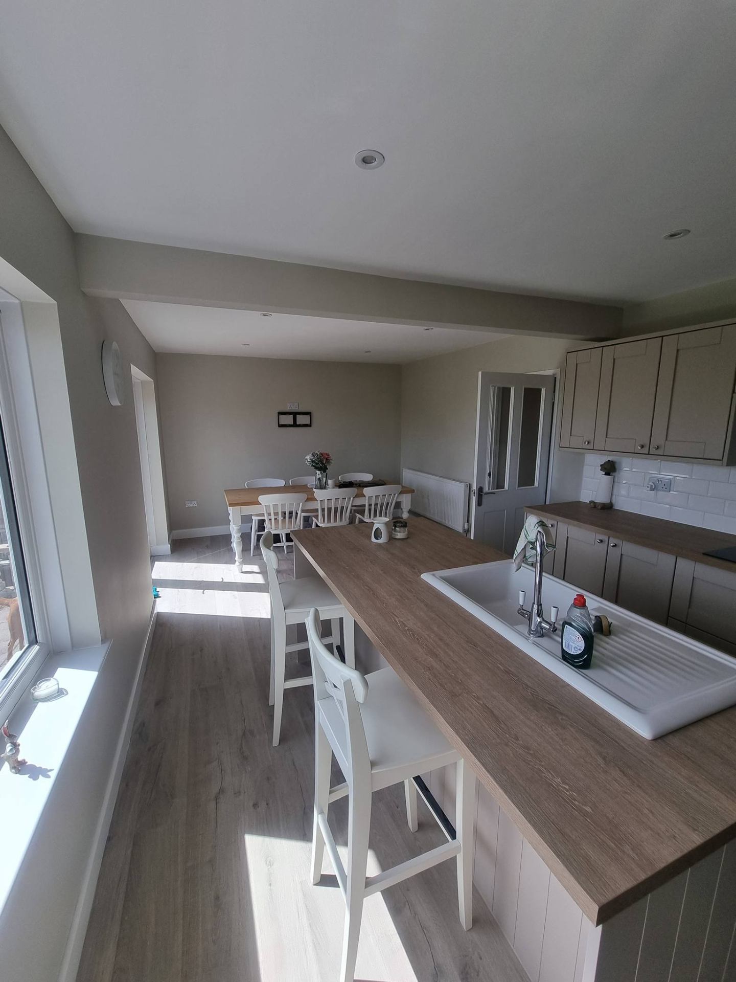 Bright cream kitchen with painted cabinets and dining area