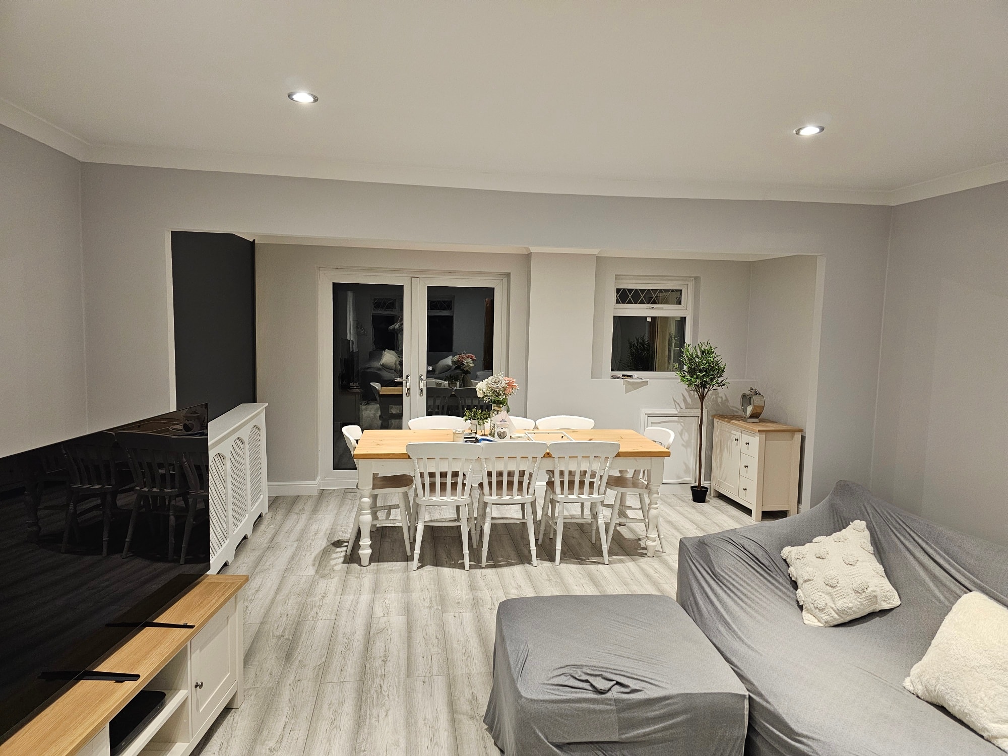 Open-plan dining and lounge with subtle dark feature panel