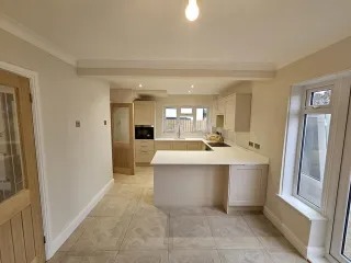 Cream open-plan shaker kitchen after a cabinet repaint