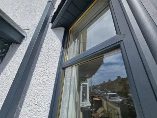 Sprayed anthracite-grey UPVC window restoration on a Newport home